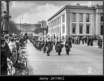 WW2 Nazi Germany occupation in Oslo Norway 1940-04-09 Wehrmacht soldiers marching Karl Johans gate Slottet. People watching with mounted police World War II Nazi occupation Oslo Norway 1940 Troops of the Wehrmacht, the military forces of Nazi Germany, in Oslo, Norway on April 9, 1940, the first day of the German invasion and occupation of Norway in World War II. The soldiers are equipped with greatcoats, jack boots, steel helmets, MP 40 sub machine guns,etc Oslo Norway Stock Photo