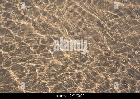 RIPPLES IN THE SAND PHOTOGRAPHED THROUGH THE SEA WATER Stock Photo