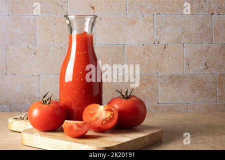 Glass bottle with homemade tomato sauce and ripe tomatoes Stock Photo