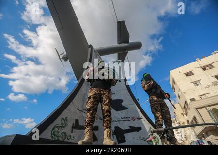 Gaza City, Palestinian Territories. 21st Sep, 2022. Members of Izz ad-Din al-Qassam Brigades, the military wing of the Palestinian Hamas Islamist movement in the Gaza Strip, stand guard next to a model of locally made drone 'Shehab' during the inauguration of 'Shehab Square'. The suicide drone is built by Hamas to carry explosive warheads and can travel for long distances. Al-Qassam Brigades claimed to have used the drone during the 2021 Israel·Palestine crisis. Credit: Mohammed Talatene/dpa/Alamy Live News Stock Photo