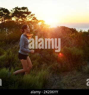 When your legs are tired, run with your heart. a beautiful brunette training outdoors. Stock Photo