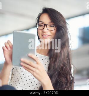 This OS runs so smoothly. a attractive young woman using a digital tablet. Stock Photo
