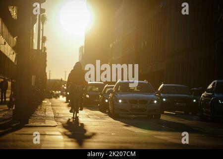 Berlin, Germany. 21st Sep, 2022. Cyclists and cars drive across Leipziger Straße in the low sun. Credit: Kay Nietfeld/dpa/Alamy Live News Stock Photo