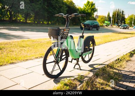 Modern green electric bike battery on a cycle in the street for rent Stock Photo