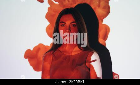 Donor day. Blood donation. People healthcare. Volunteer charity. Friendly young woman in bright red color paint flow drip projection light on white ba Stock Photo