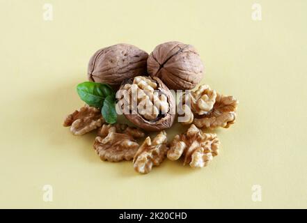 Group of walnuts isolated on a yellow background. Vegetarian or vegan food concept. Directly above. Copy space. Stock Photo