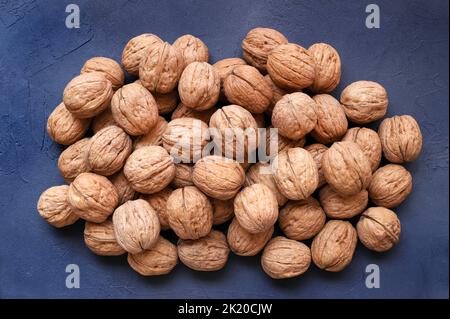 Group of walnuts isolated on blue background. Directly above. HDR walnuts photography. Stock Photo
