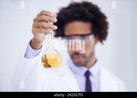 This looks promising. a male scientist conducting an experiment in his lab. Stock Photo