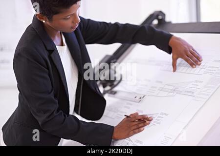 She prides herself in her accuracy. a female architect working at a drawing board. Stock Photo