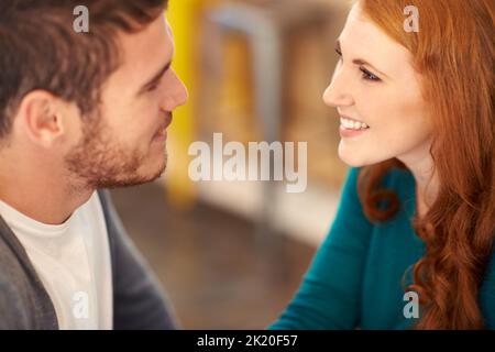 The greatest feeling on earth. A cropped shot of a young affectionate couple on a coffee date. Stock Photo