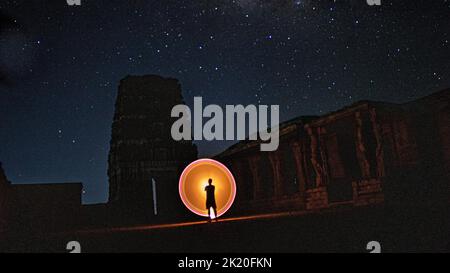 Kodanadu, Tamilnadu, India - March 14 2021 : one person standing against beautiful colorful circle light painting as the backdrop. light painting port Stock Photo