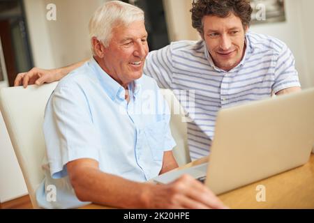 Showing his dad a thing or two. a man and his father using a laptop indoors. Stock Photo