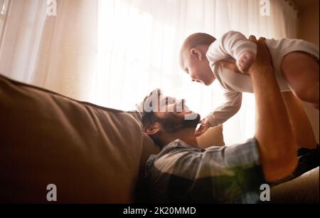 She lifts his spirits. an affectionate father bonding with his baby girl at home. Stock Photo