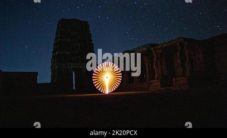 Kodanadu, Tamilnadu, India - March 14 2021 : one person standing against beautiful colorful circle light painting as the backdrop. light painting port Stock Photo