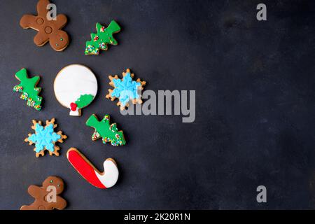 Assorted Christmas cookies in the shape of a Christmas tree, Gingerbread man, Snowflake, candy can on dark background Stock Photo