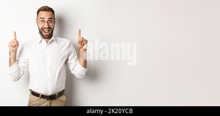 Excited businessman checking out advertisement, pointing and looking up ...