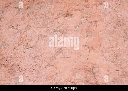 The texture of old painted concrete. The concrete background is dusty pink. The background of a painted wall with cracks. Stock Photo