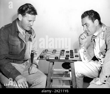 Technical Advisor Major MORRIS H. WHYTE of the British Indian Army 8 Battalion Burma Rifles and ERROL FLYNN on set candid playing Checkers during a break in filming of OBJECTIVE BURMA ! 1945 director RAOUL WALSH original story Alvah Bessie music Franz Waxman producer Jerry Wald Warner Bros. Stock Photo