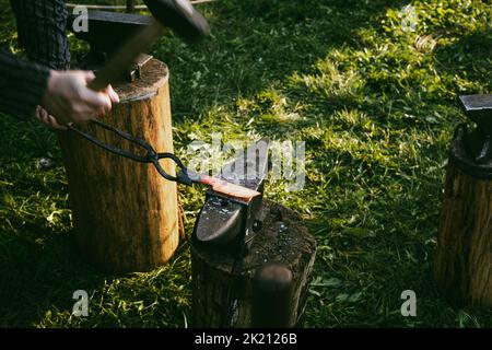 A man forging a knife, blacksmith's workshop in the open air. Stock Photo