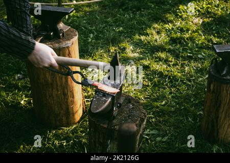 Blacksmith's workshop in the open air. The process of forging a knife. Stock Photo