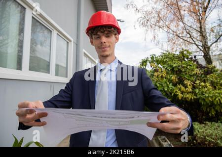 The engineer checks the cartography and floor plan of the work that follows. Stock Photo