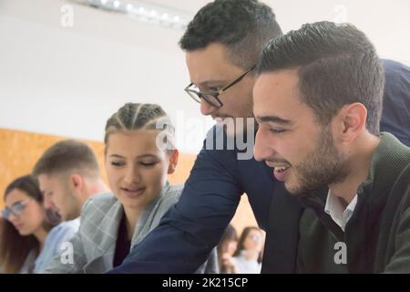 Professor having discussion with his college students Stock Photo