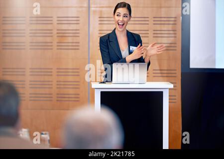 Joy is the engine of growth. A beautiful young businesswoman giving a presentation at a press conference. Stock Photo