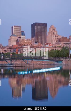 Montreal Skyline and footbridge reflected in Bonsecours Basin at dawn in spring, Old Port of Montreal, Quebec, Canada. Stock Photo