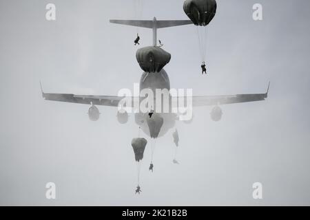 Anchorage, United States. 24 August, 2022. Anchorage, United States. 24 August, 2022. U.S. Army paratroopers assigned to the 2nd Infantry Brigade Combat Team, 11th Airborne Division, also known as Arctic Angels, jump from an Air Force C-17 Globemaster III aircraft at Malemute drop zone, August 24, 2022, in Joint Base Elmendorf Richardson, Alaska. Stock Photo