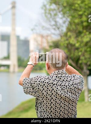 Senior man using smartphone to take photos and video. Travel and technology lifestyle for seniors. Stock Photo