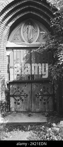 A grayscale vertical shot of an old gate of a building Stock Photo