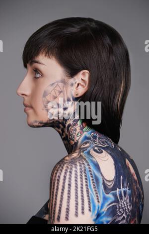 Wear your art on your sleeve. A cropped studio shot of a beautiful young tattooed woman. Stock Photo