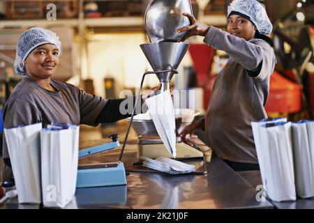 We only bag the best. workers in a coffee packaging and distribution warehouse. Stock Photo