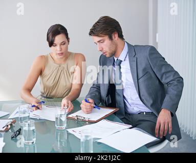 Coming up with a new strategy. two business colleagues discussing paperwork in a meeting. Stock Photo
