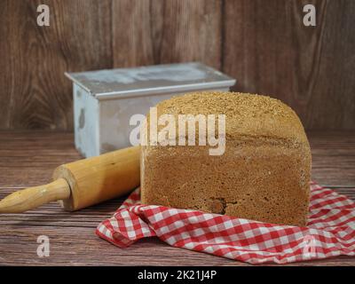 closeup of homemade bread with bakery utensils on red and white checkered tablecloth and wooden background Stock Photo