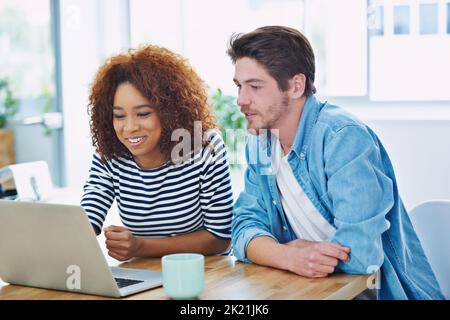 Together everyone achieves more. two coworkers working together at their desks. Stock Photo