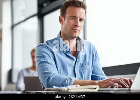 Success is serious business. a man working on a laptop in an office. Stock Photo