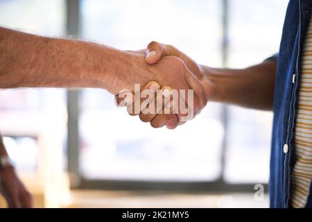 Establishing solid bonds. Cropped view of two men shaking hands indoors. Stock Photo