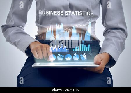 Analyzing business data with the help of technology. a businesswoman using a digital tablet to analyze financial data. Stock Photo