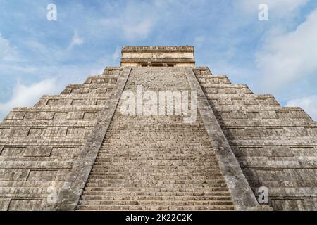 View up the main stone steps of El Castillo (Temple of Kukulkan) in Chichen Itza with blue sky Stock Photo
