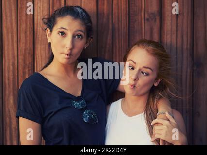 Its better to be absolutely ridiculous than absolutely boring. Two teenage friends making funny faces while spending time together. Stock Photo