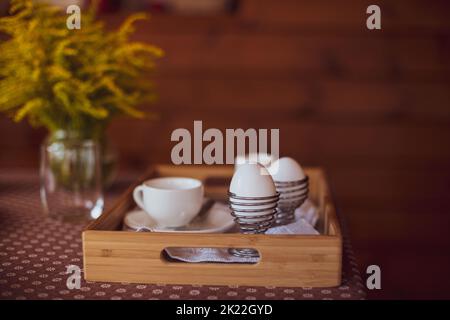 Breakfast preparation. Two bpiled white chicken eggs in stainless steel spiral holders Stock Photo