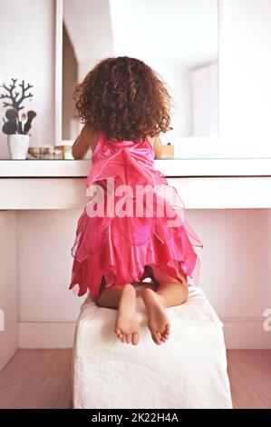 In front of the mirror is where youll find me. Rear view shot of a little girl looking at herself in the mirror. Stock Photo