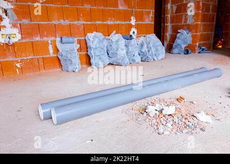 Concrete blocks and plastic pvc sewage pipe on palette on building