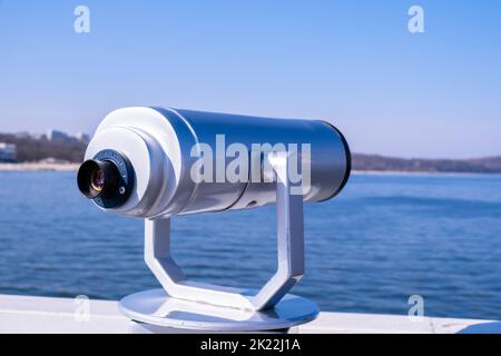 Tourist binoculars. Binocular telescope on the observation deck for tourism. Sea background. Binoculars watching at horizon at ship deck. Travel tourist destination attraction. Copy space for text. Sopot on the pier Stock Photo