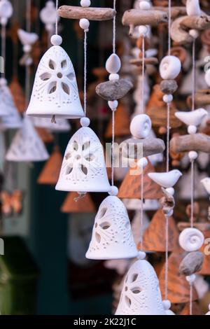 Ceramic handycrafts sold in the shops sold in Sopot Poland. Candid authentic souvenir travel idea gifts. Clay bells hang on a rope. Shallow depth of field Stock Photo