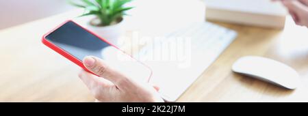 Smartphone in hand of people at workplace Stock Photo