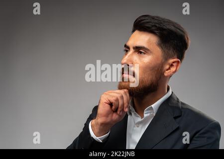 Studuo shot of thinking businessman standing over gray background Stock Photo