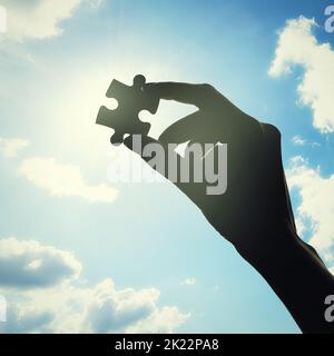 This has to go somewhere. Conceptual shot of a persons hand building a puzzle. Stock Photo