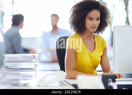 Focused on the job at hand. an attractive young businesswoman working at her office desk. Stock Photo